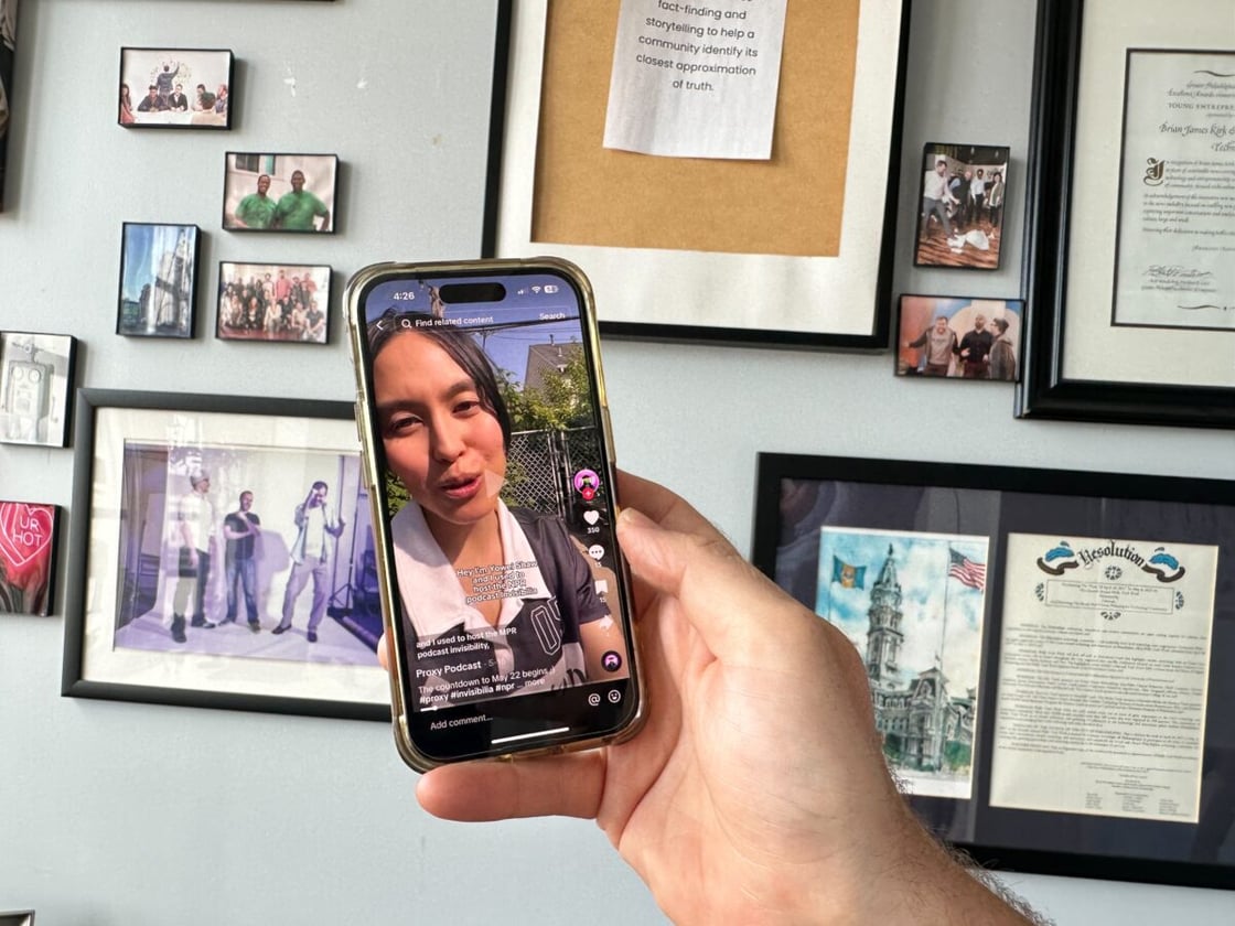 Woman in white collared shirt on TikTok via phone screen held in a hand.