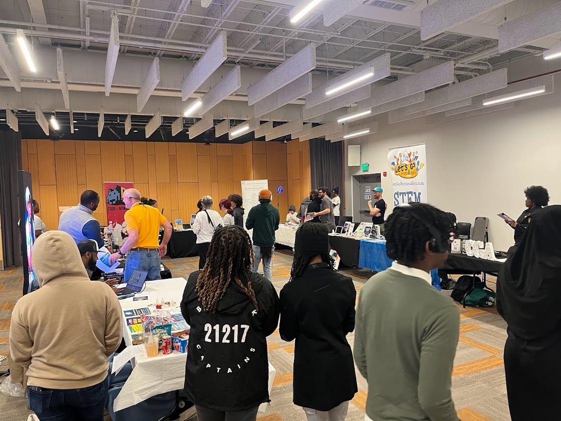 Young people at a career fair near tables with accompanying vertical signs