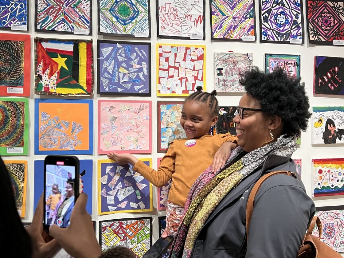 Woman and child in front of multicolored art pieces