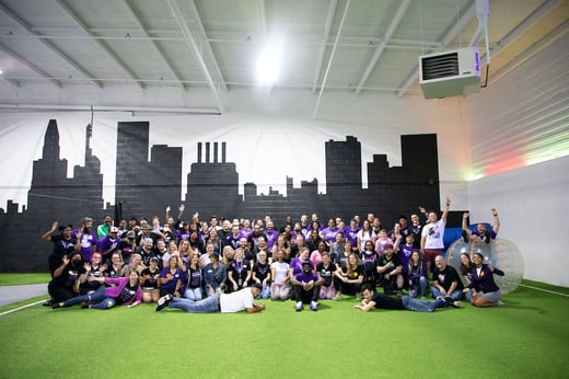 The team at Fearless posing for a group photo in front of a mural of the Baltimore skyline silouette.