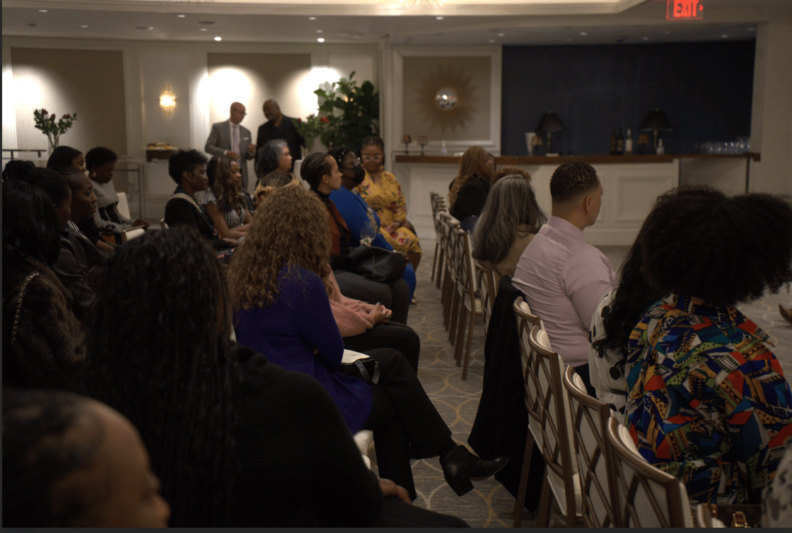 People in gold chairs in dimly lit room.