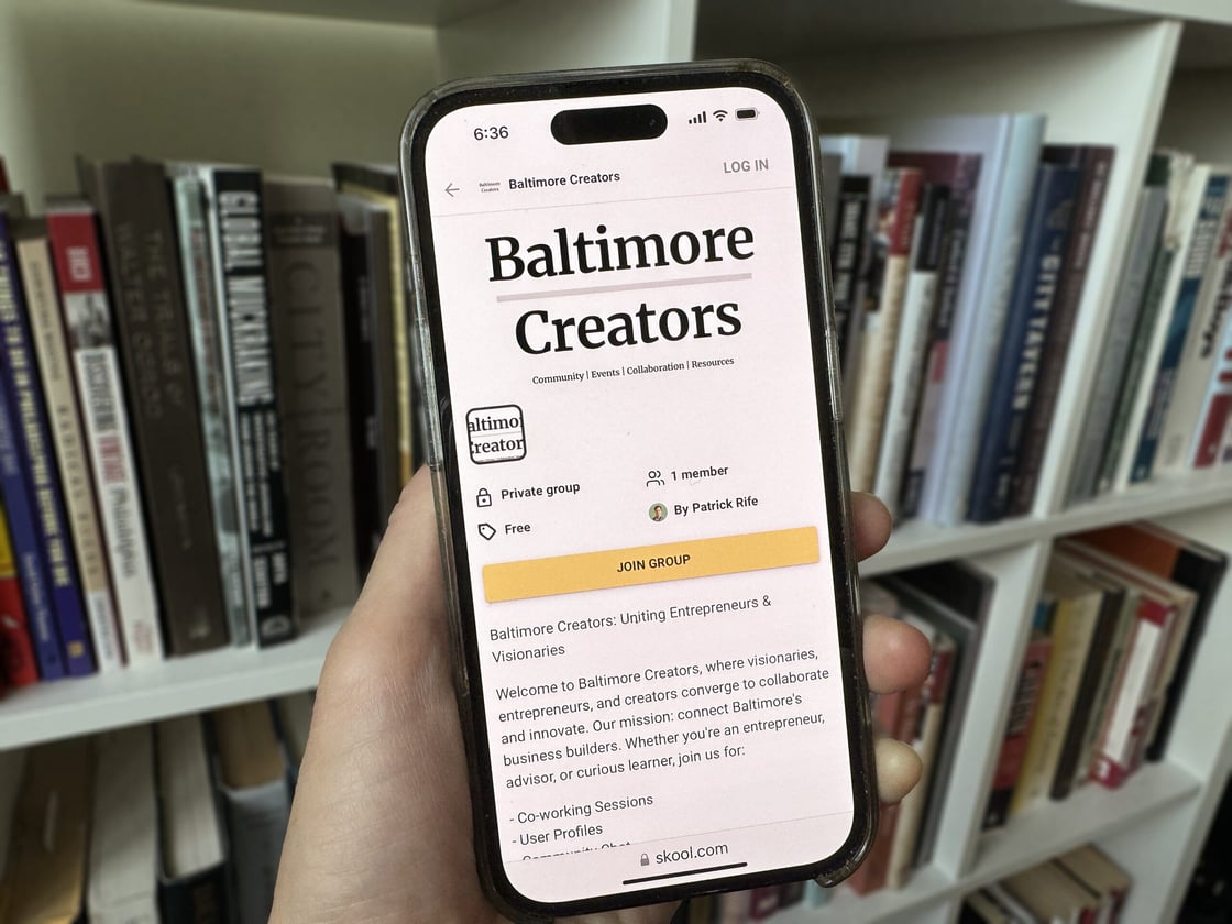 Baltimore Creators platform with black text and yellow button on mobile phone screen.